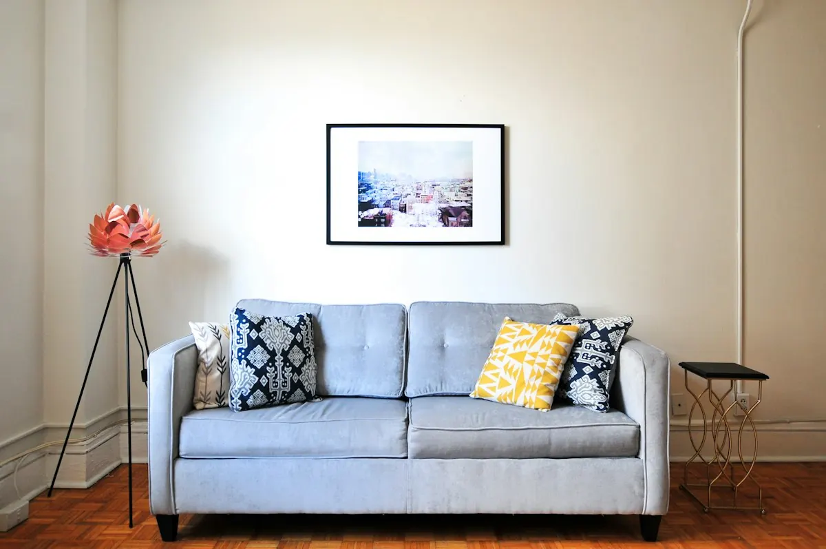 Tidy living room with a blue sofa and framed print