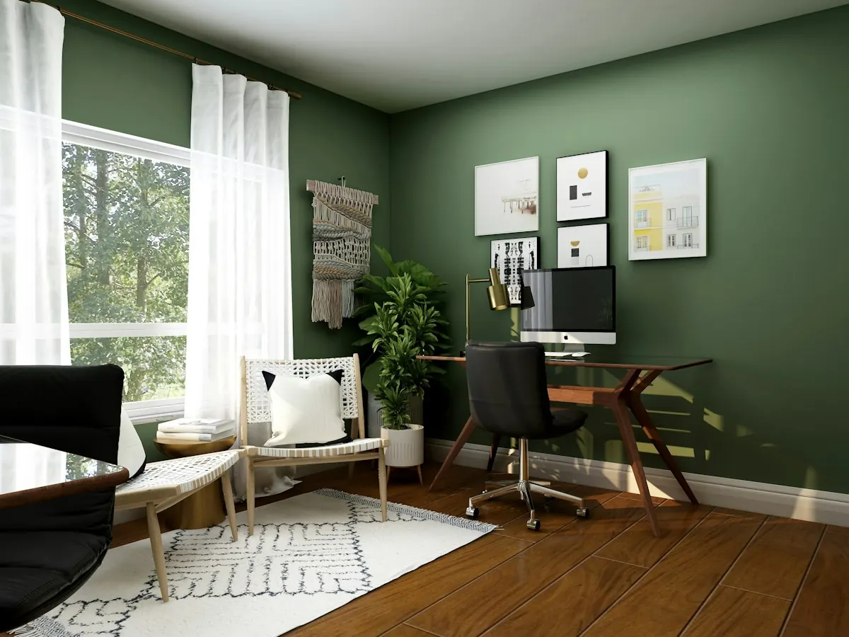 Calm home office with a desk, sage green wall and plants