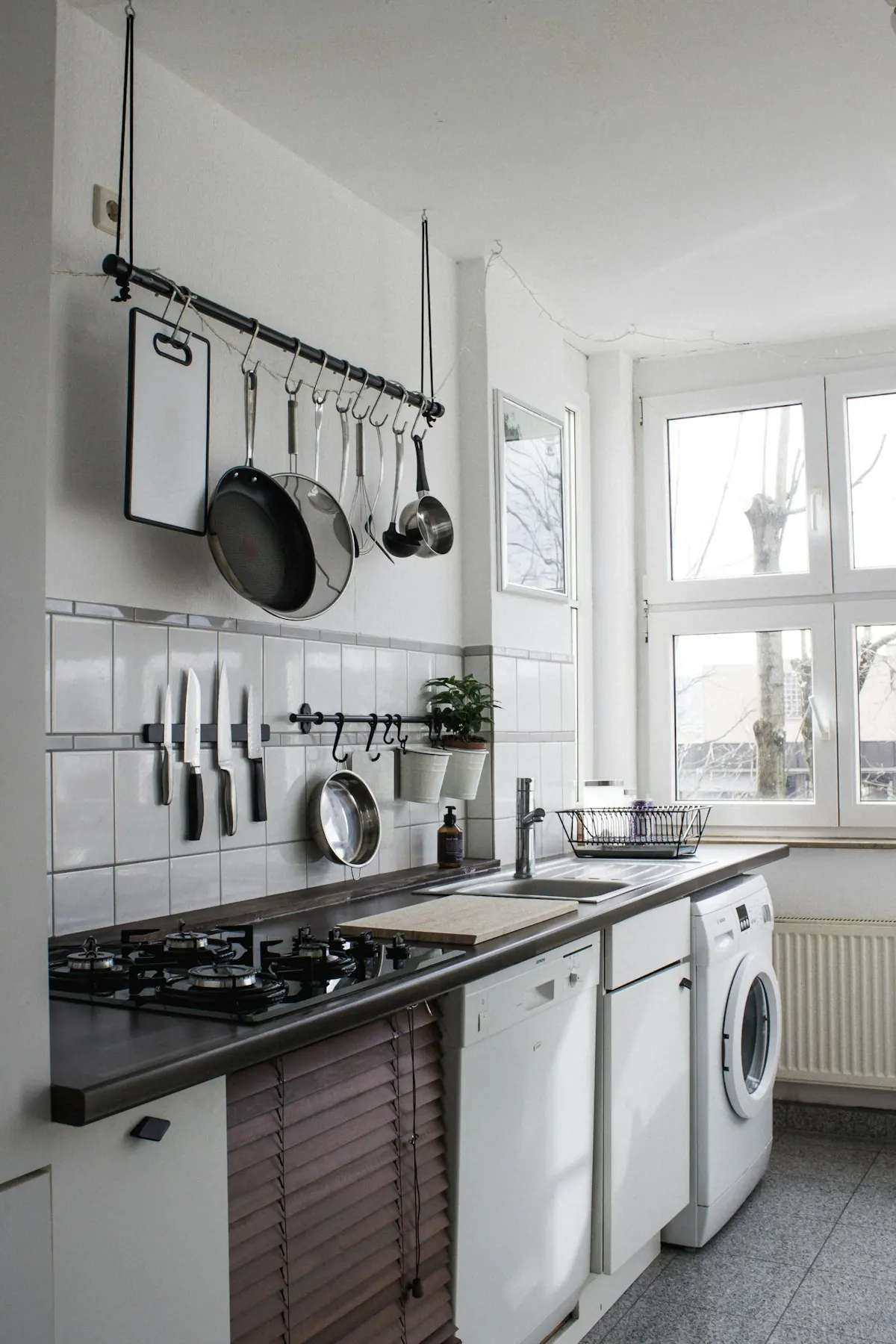 Kitchen wall rail holding pans and utensils above the counter