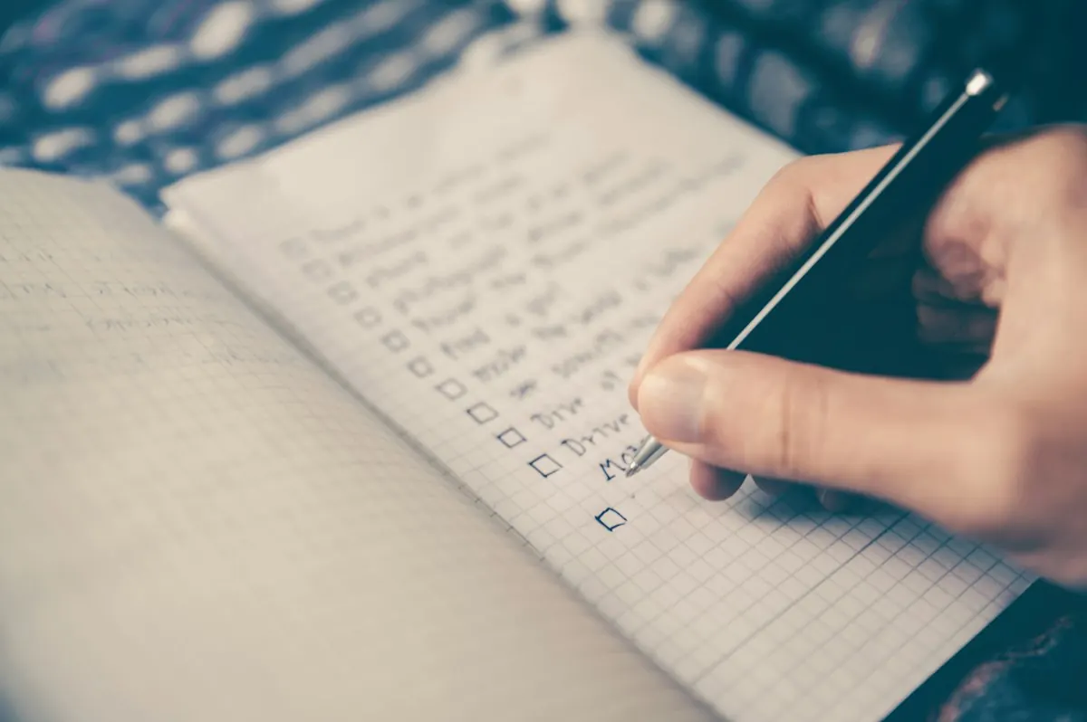 Hand writing an organizing checklist in a notebook